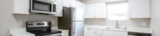 an empty kitchen with white cabinets and stainless steel appliances at Ascent on Peoria Apartments, Phoenix, AZ
