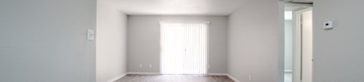 an empty living room with white walls and wood flooring at Ascent on Peoria Apartments, Phoenix