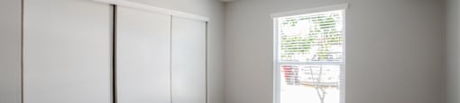 an empty room with white walls and wood flooring and a window at Ascent on Peoria Apartments, Phoenix, Arizona