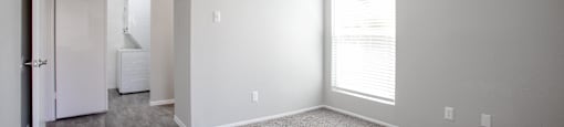 an empty living room with carpet and a large window at Ascent on Peoria Apartments, Arizona, 85029