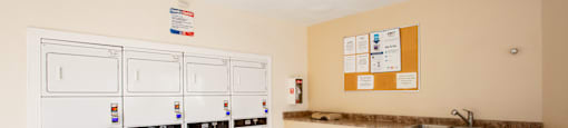 A kitchen with white appliances and a brown counter.