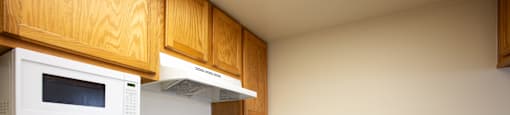 A kitchen with a white oven and microwave.