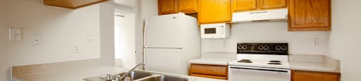 A kitchen with wooden cabinets and white appliances.