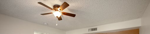 A room with a ceiling fan and a white counter.