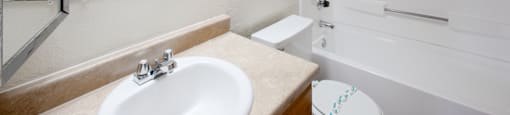 A white bathroom with a sink, toilet, and bathtub.