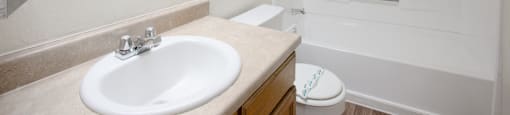 A white bathroom with a sink, toilet, and bathtub.