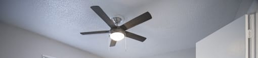 an empty room with a ceiling fan and a window