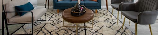 a living room with a blue couch and three chairs at Ascent on Peoria Apartments, Phoenix, Arizona