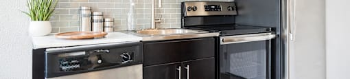 a kitchen with modern cabinets and stainless steel appliances at Nextloft Apartments, Bluffton, SC