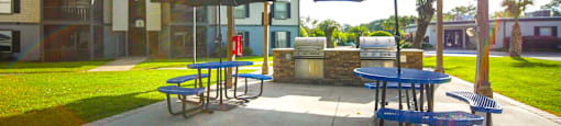 a patio with picnic tables and umbrellas at Planters Trace Apartment Homes, South Carolina, 29414