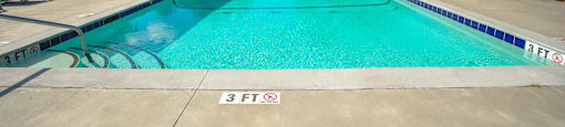 a swimming pool with blue chairs around it in front of a building at Planters Trace Apartment Homes, Charleston, SC 29414
