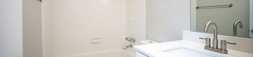 a bathroom with a sink toilet and a tub at Planters Trace Apartment Homes, Charleston, SC