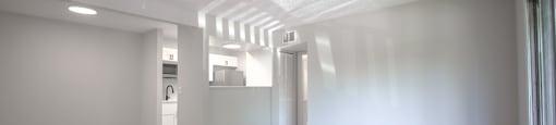 an empty living room with white walls and wood flooring