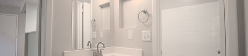 a bathroom with a sink and a mirror and a shower at Planters Trace Apartment Homes, South Carolina
