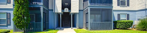 front view of an apartment building with a sidewalk and grass at Planters Trace Apartment Homes, Charleston