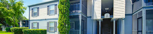front view of an apartment building with a sidewalk and grass at Planters Trace Apartment Homes, Charleston, 29414
