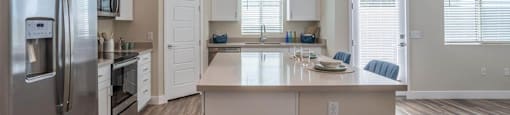 Open floor plan shows a kitchen with a large island in an apartment at Village Greens of Queen Creek
