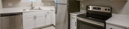 a kitchen with white cabinets and stainless steel appliances