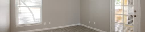 a bedroom with hardwood floors and a door leading to a balcony at Ascent on Peoria Apartments, Arizona