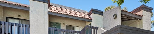 A modern house with a balcony and a grey door.