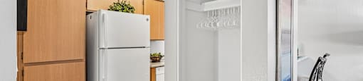 A kitchen with a white fridge and wooden cabinets.