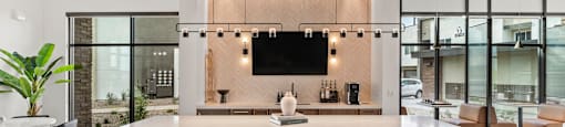 A modern kitchen with a long island and chairs.