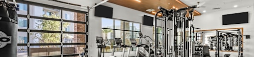 A gym with a variety of equipment including a punching bag.