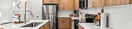 A modern kitchen with wooden cabinets and stainless steel appliances.
