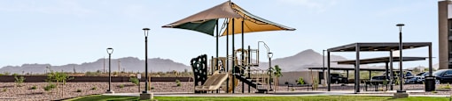 A playground with a slide and a canopy is in the foreground.