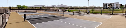 A tennis court with a net and two courtside buildings.