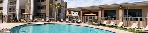 A swimming pool in front of apartment buildings.