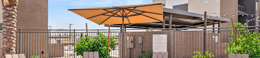 A patio area with a table, chairs, and a parasol.