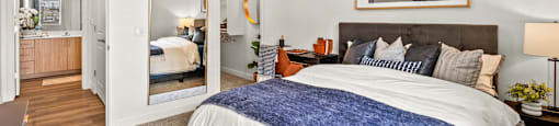 A bedroom with a bed, a ceiling fan, and a painting on the wall.