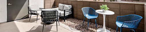 A patio with a table and chairs overlooking a building.