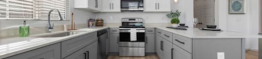 a large kitchen with white cabinets and a white counter top