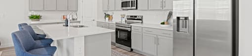 A modern kitchen with a white island and stainless steel appliances.