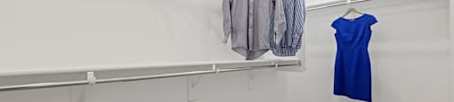 A room with a clothes rack and two baskets on the floor.