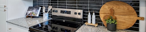 A kitchen with a black stove top oven and a black microwave above it.