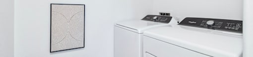 A white washing machine and dryer in a small laundry room.