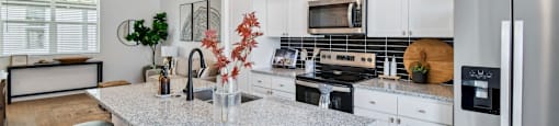 A kitchen with a granite countertop and white cabinets.