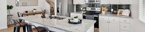 A kitchen with a granite countertop and bar stools.