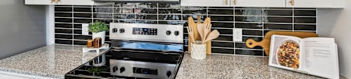 A kitchen with a black stove top oven and a microwave above it.