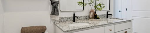 A white bathroom with a towel on the toilet.