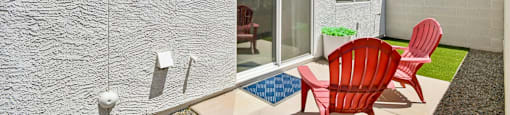 Two red chairs are placed on a patio.