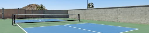 A tennis court with a flag on top of a wall.