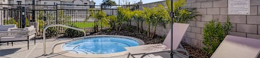 A yellow umbrella is in front of a pool.