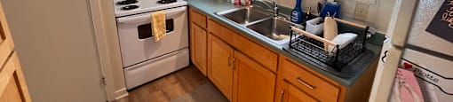 A kitchen with wooden cabinets and a white refrigerator.