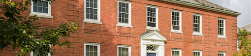 A red brick building with a white door and windows.