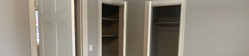 A room with a white door and two other doors with no windows.