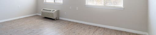 A room with a ceiling fan and two windows.